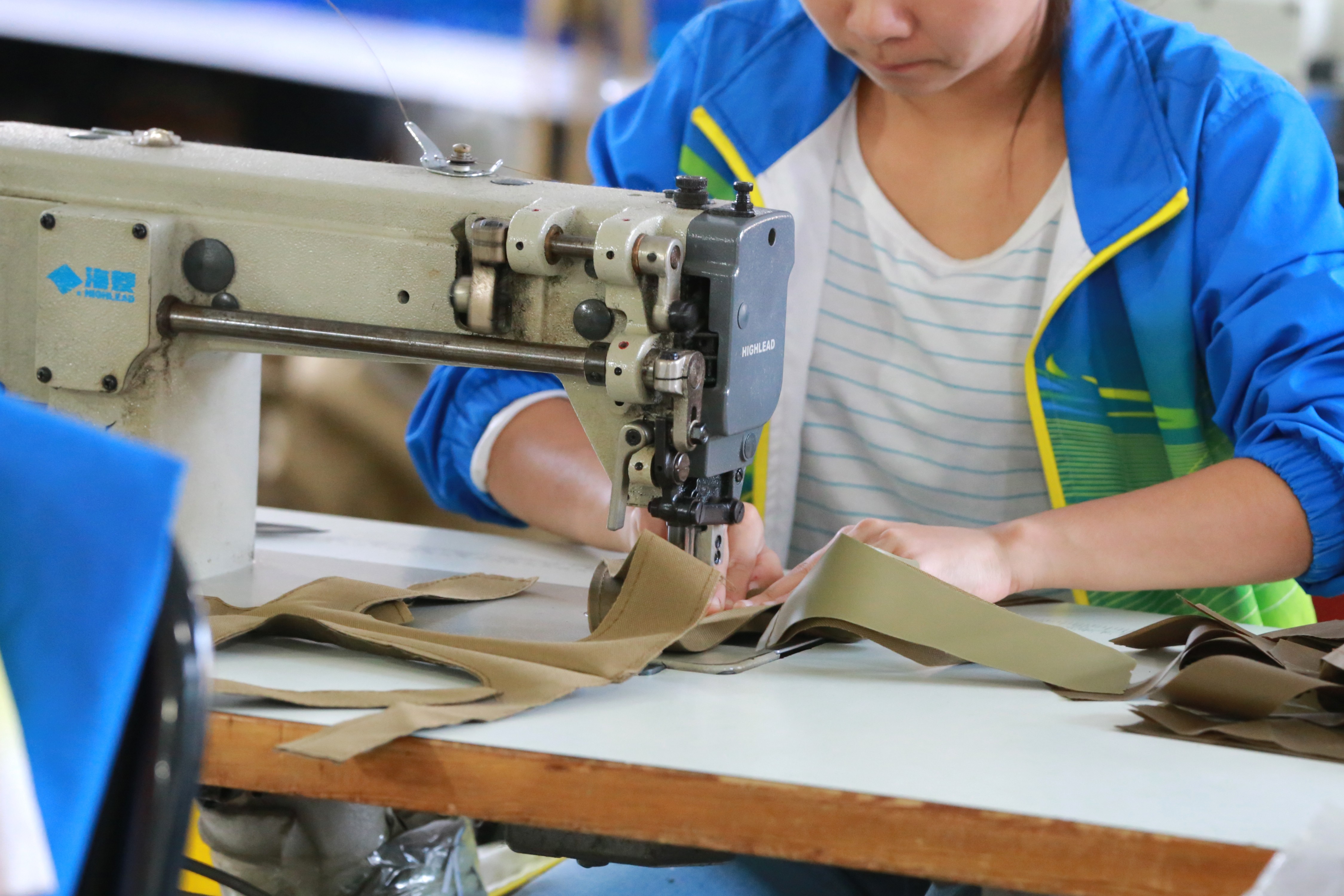 Worker sewing a bag panel at our workshop
